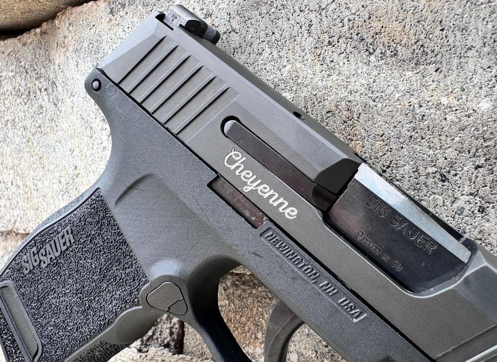 Close-up of a gray handgun with 'Cheyenne' branding on a textured surface